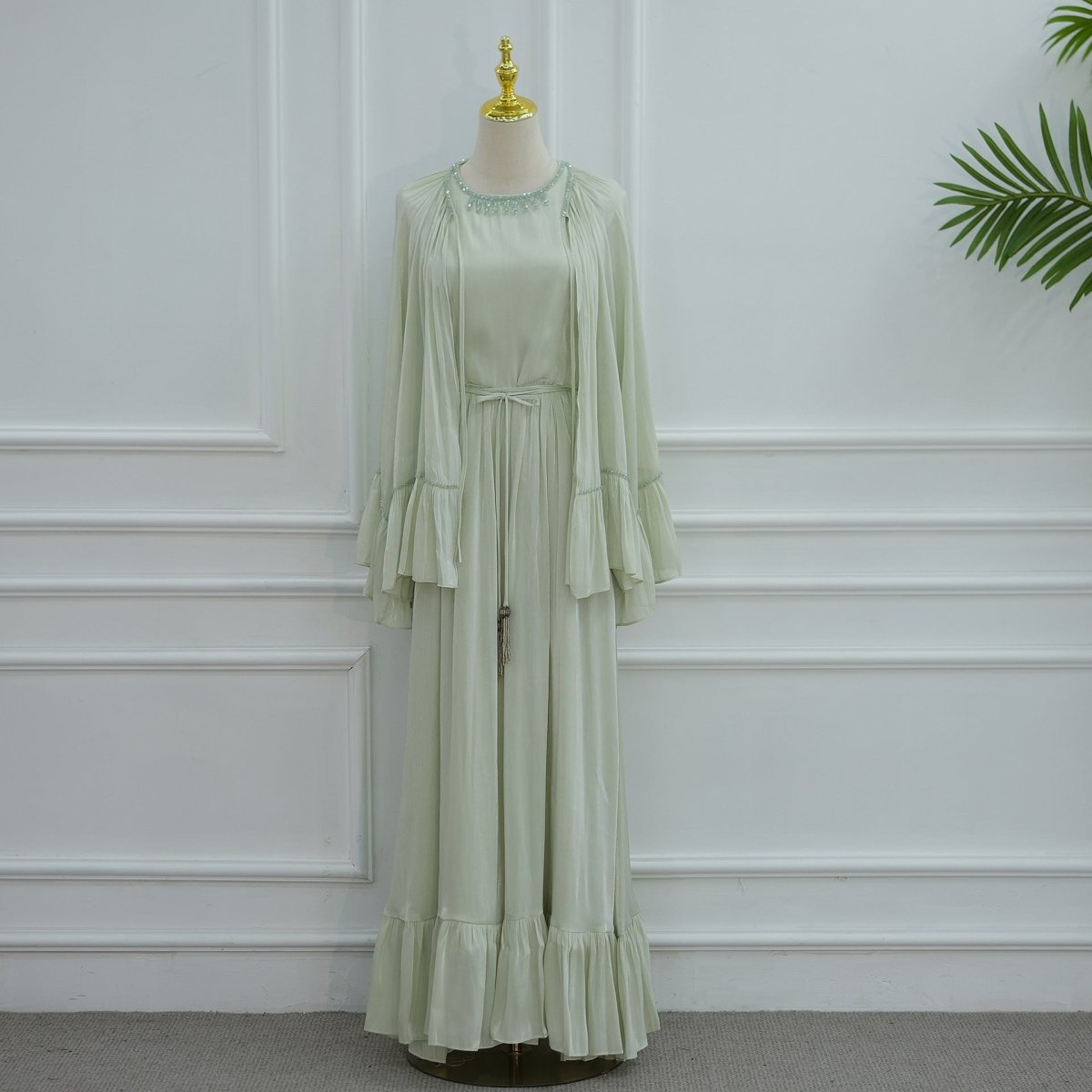 Overhead flat lay of the full 2-piece ruffle abaya set including waist belt