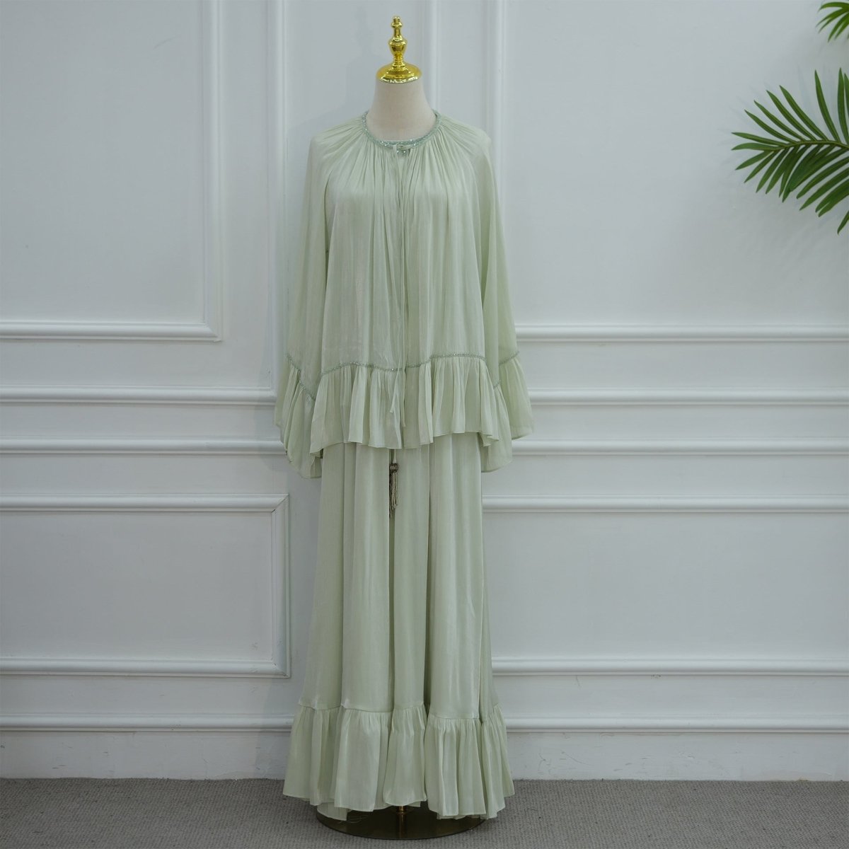 Back detail view of the ruffle hem trim and flowing cape silhouette