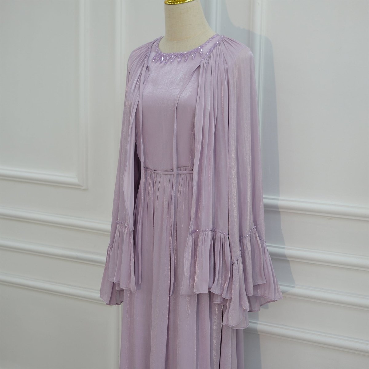 Three-quarter view showcasing the sweeping bell sleeve silhouette