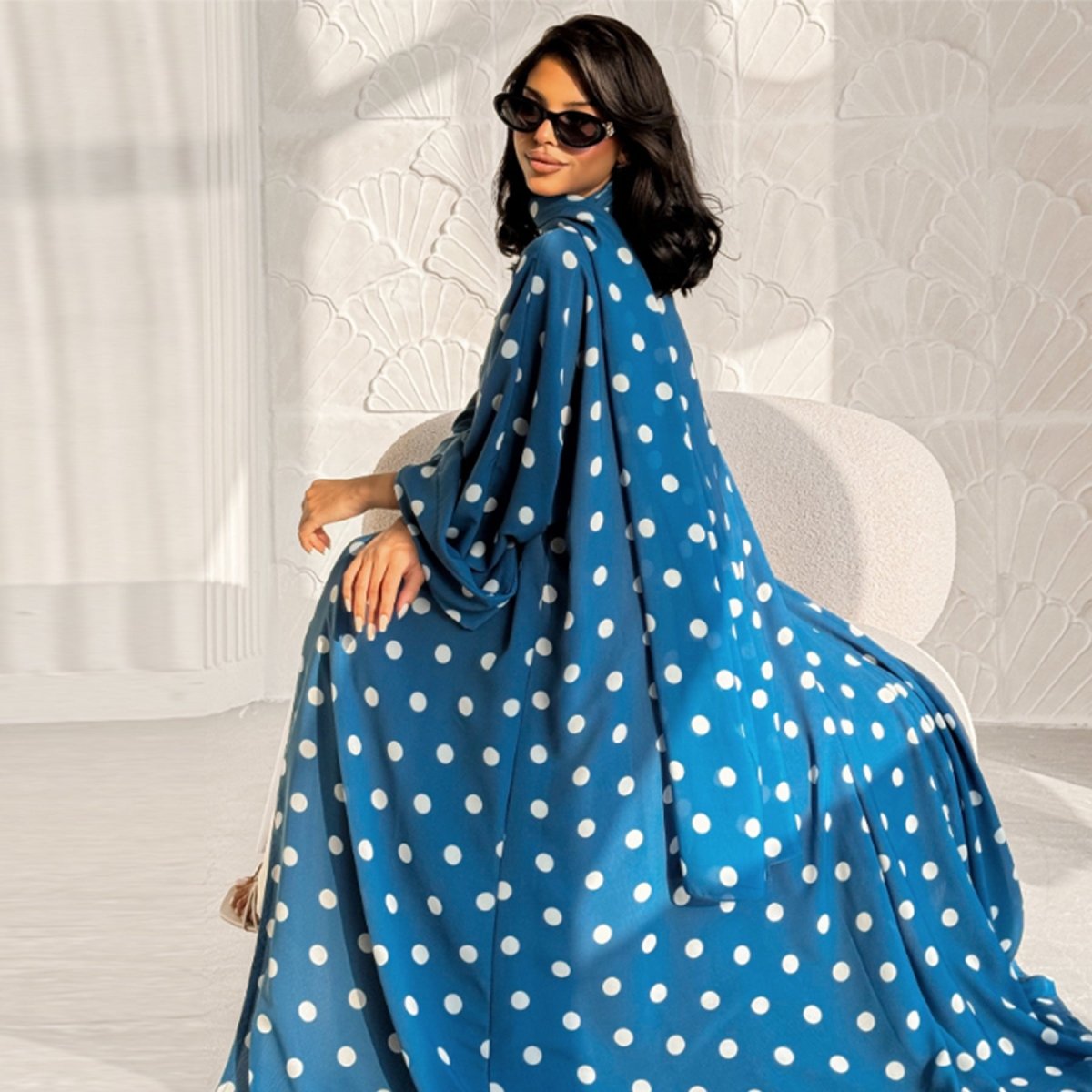 Overhead flat lay of polka dot open abaya and matching hijab