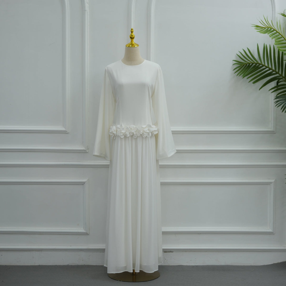 Sculptural rose waist band catching light on fitted maxi dress