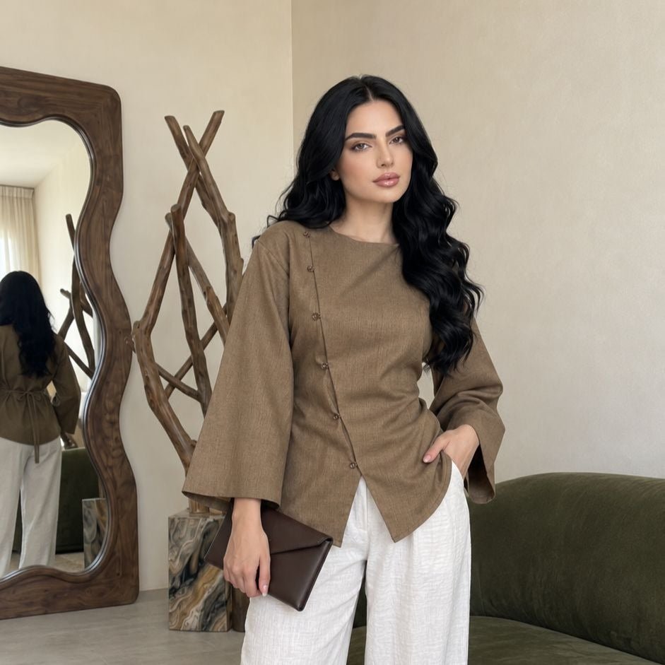 Side view showing angled overlapping hem and wide sleeve detail of asymmetric modest blouse