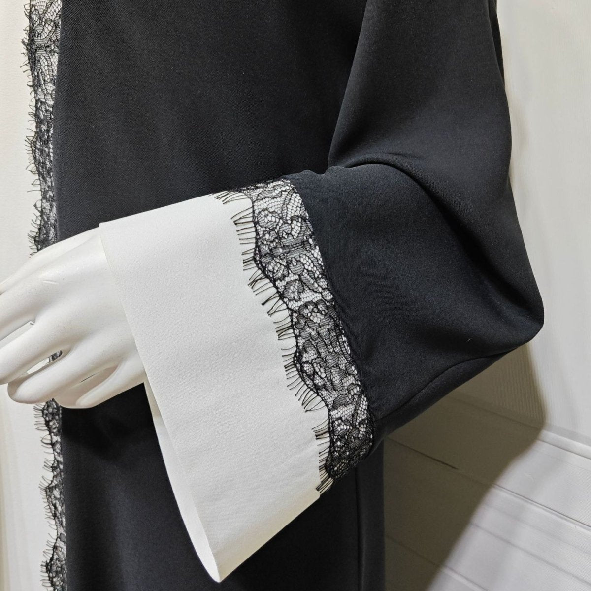 Full-length profile showing vertical elongating contrast panel on lace trim abaya