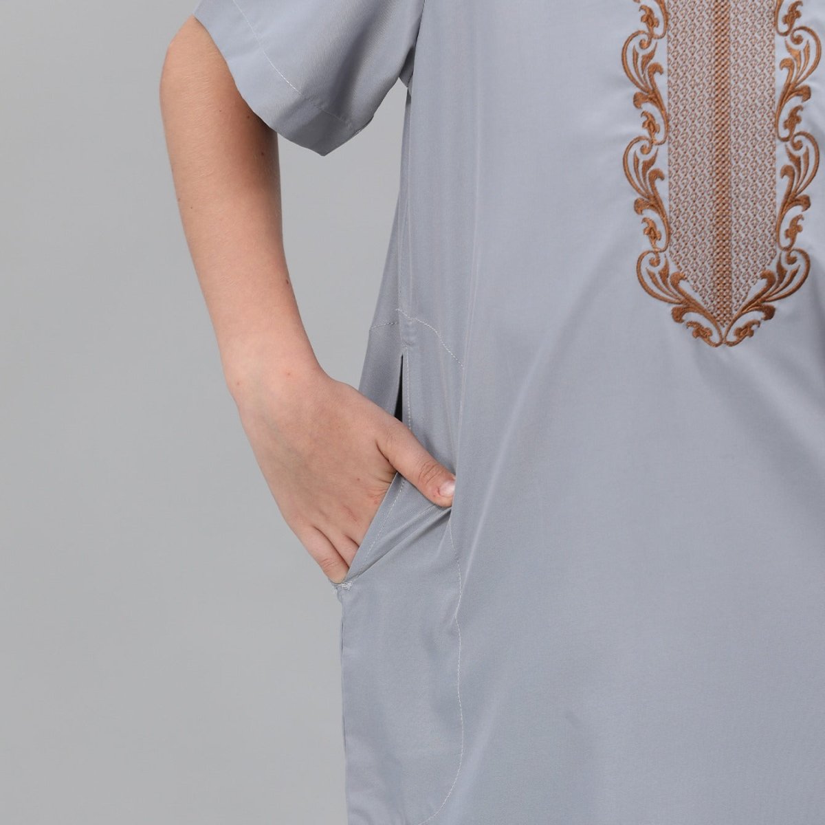 Close-up of boys' thobe side pocket and hemline detail