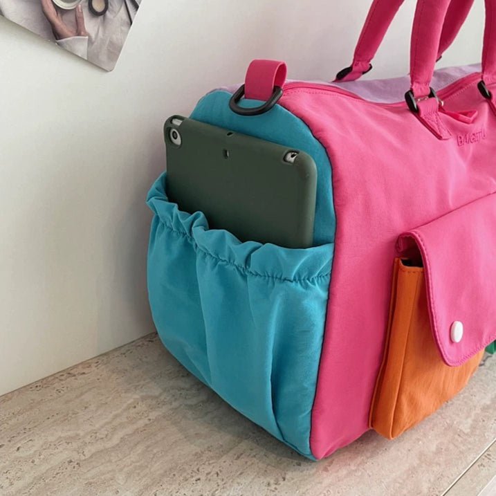 Close-up of multi-colour colorblock panelling on weekender travel bag