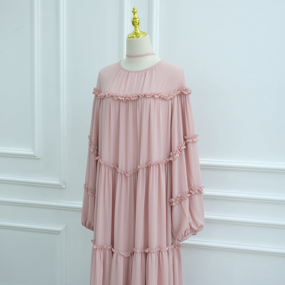 Curved seam detailing across the bodice of tiered ruffle modest dress