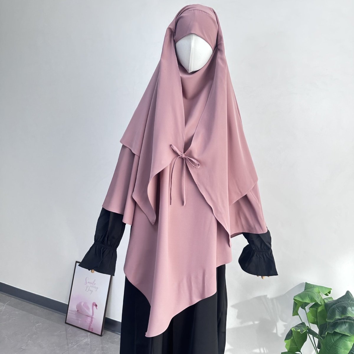 Angled view of asymmetric pointed back hem on nida prayer khimar