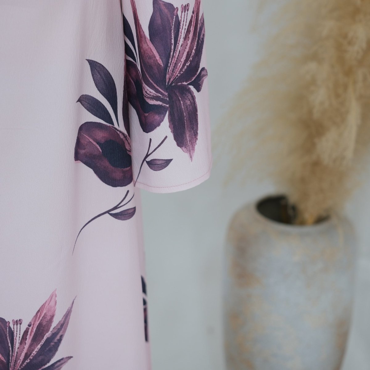 Front view of round neckline and draped cape sleeves on floral maxi