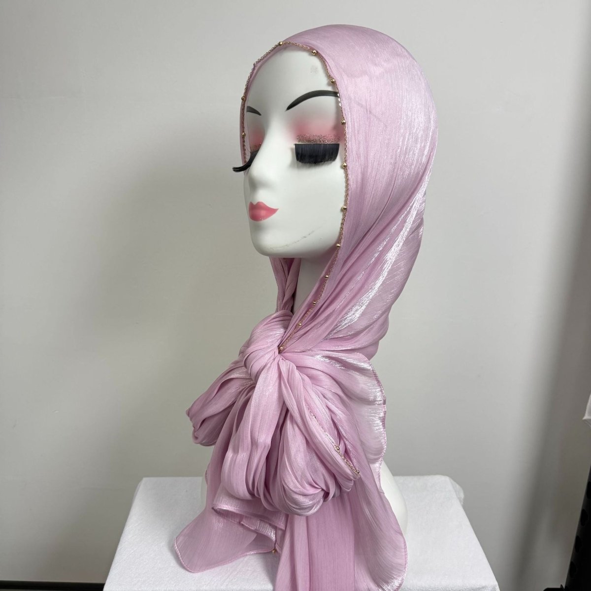 Gold chain beaded hijab in soft neutral palette laid flat