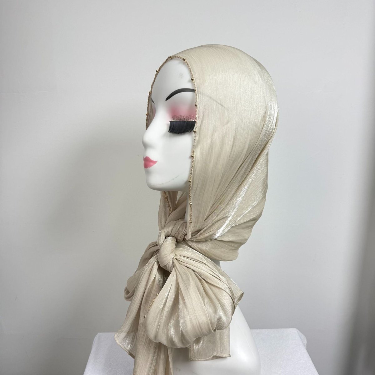 Crinkle texture close-up on shimmer satin hijab with gold trim