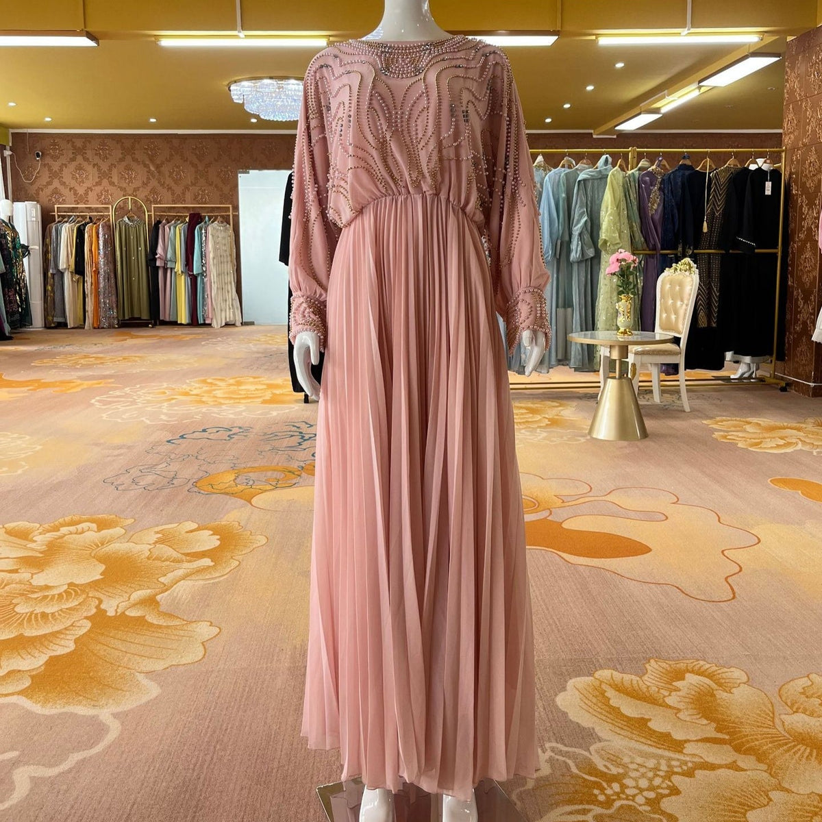 Full-length batwing sleeves with wave-line beaded embellishment to the wrist