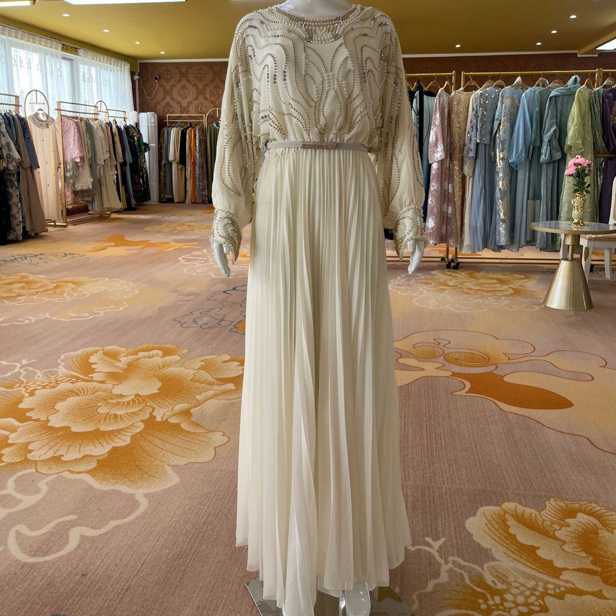 Dense uniform pleated floor-length skirt — side view showing movement