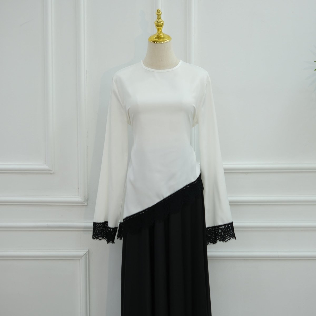 Detail shot of tonal lace hem band on satin top