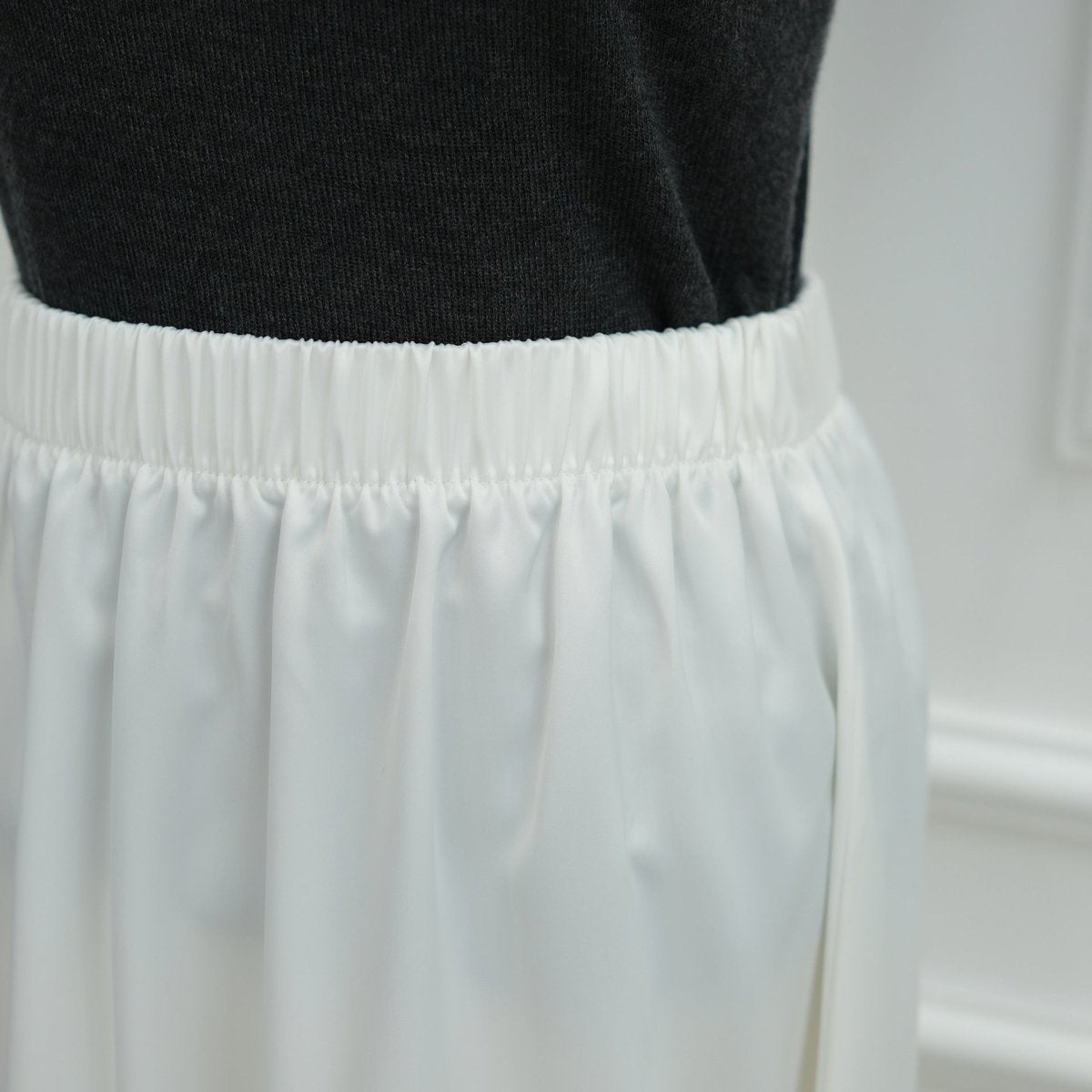 Relaxed waist ribbon styling on satin top for flowing silhouette