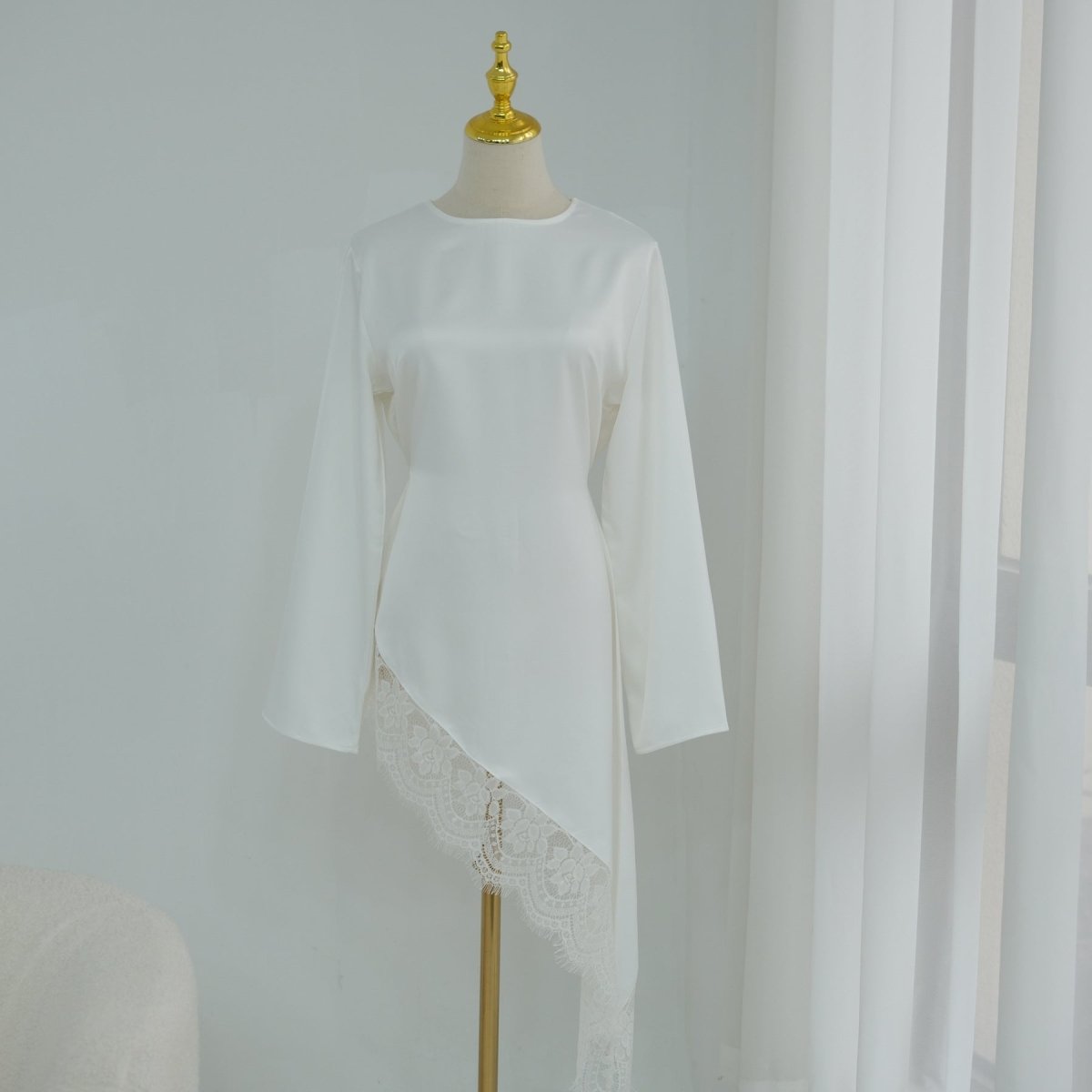 Editorial flat-lay of lace trim satin top showing lace details