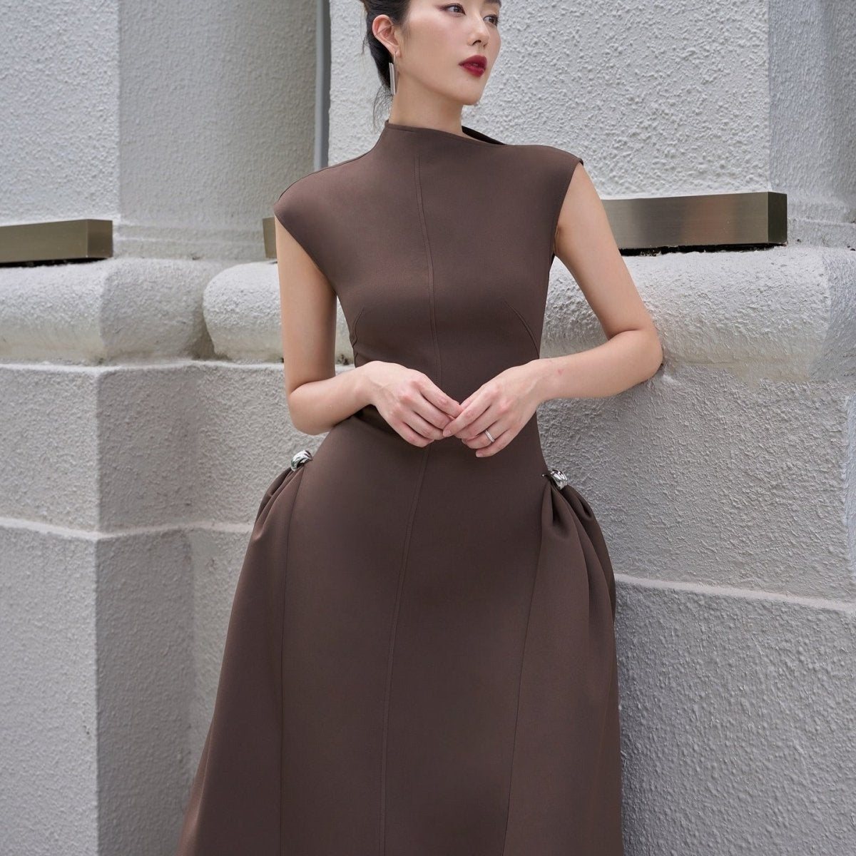 Sleeveless modest gown with asymmetric hemline and clean construction