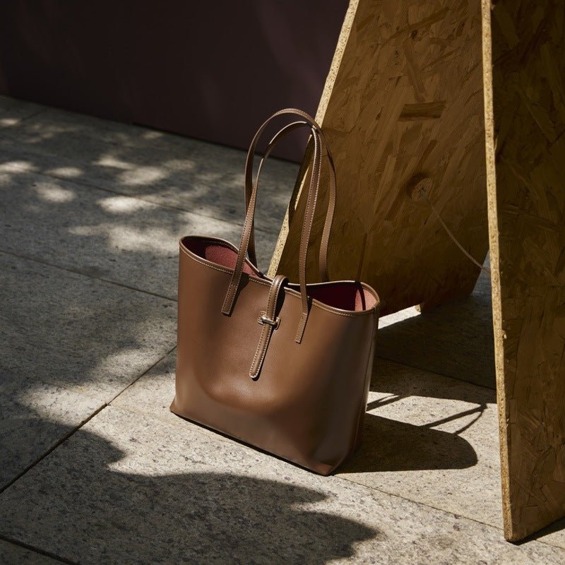 Side profile of structured minimalist tote bag showing full-length zip closure
