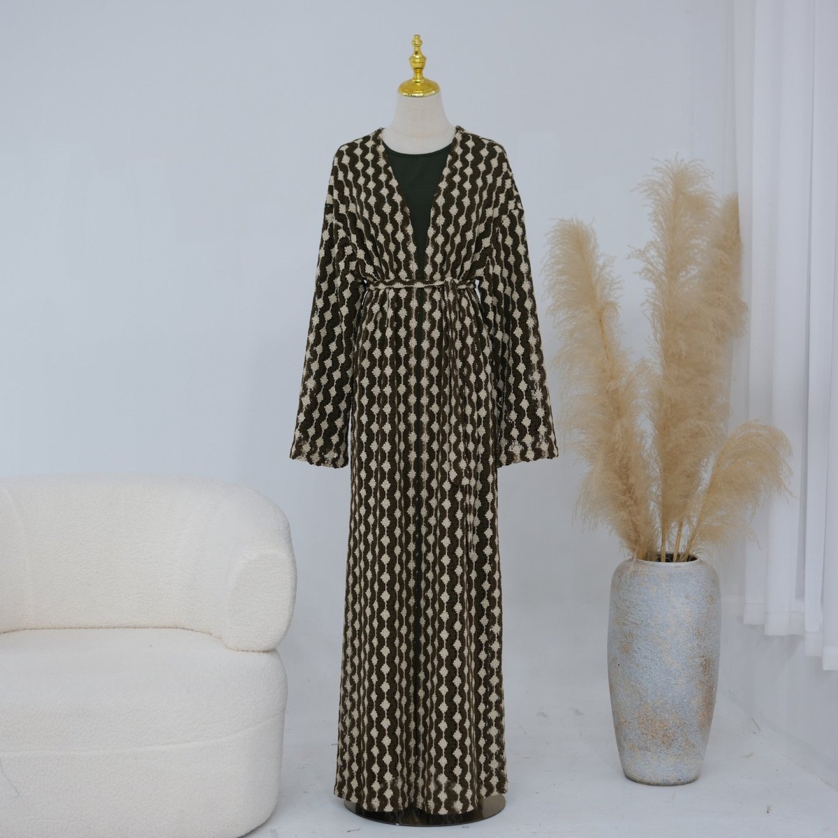 Hem detail of openwork lace knit abaya showing textured construction