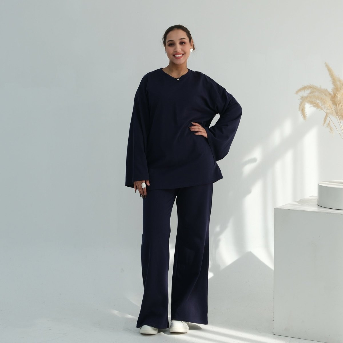 Styled flat lay of batwing top, wide-leg trousers and belt