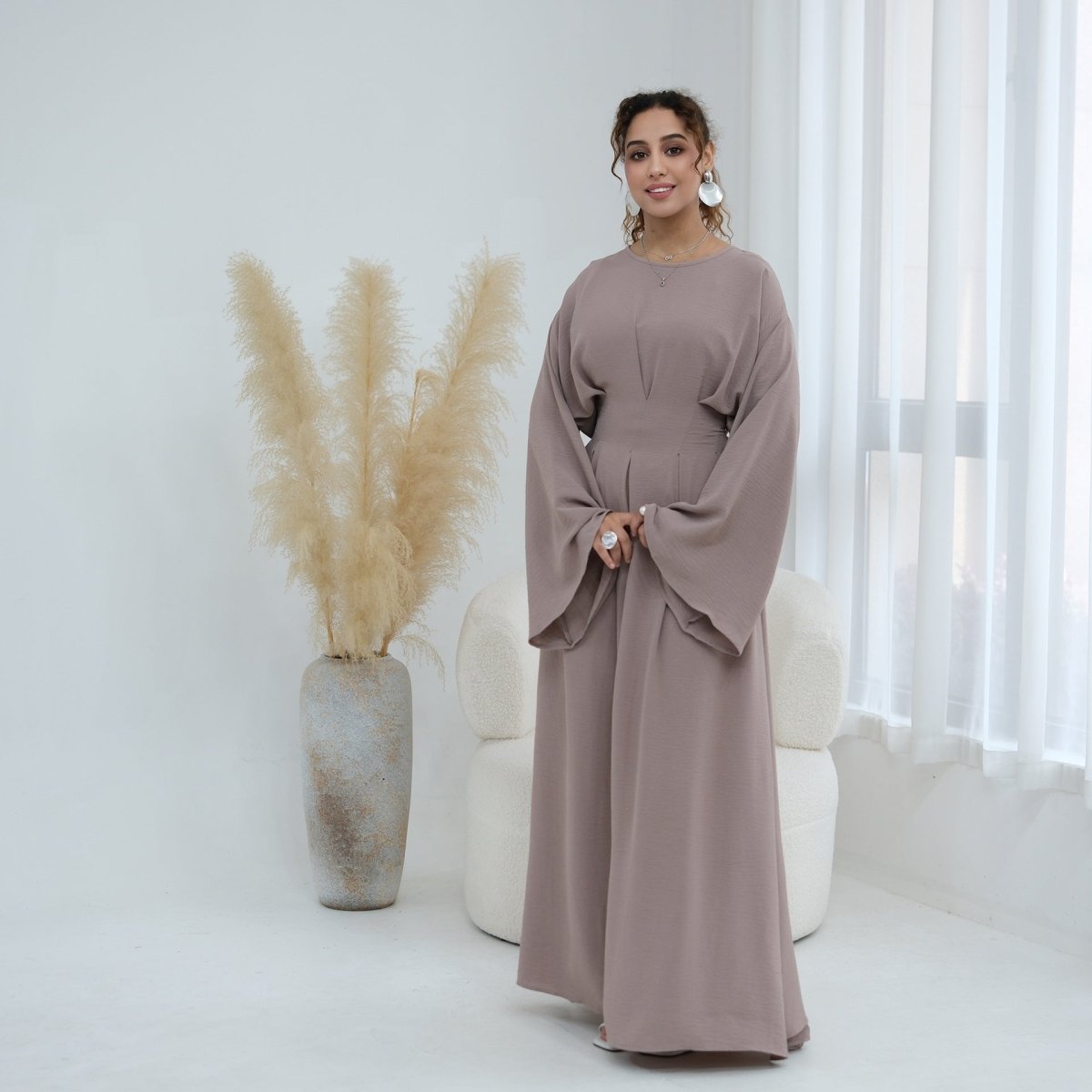 Side profile of A-line skirt and draped batwing sleeve in movement