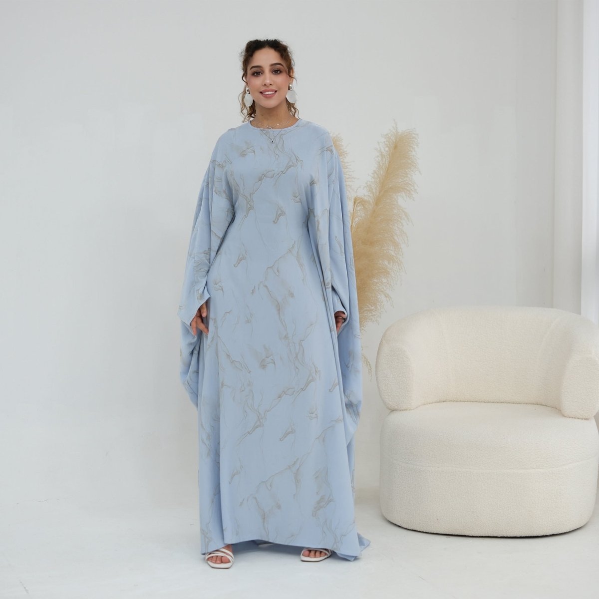 Draped batwing sleeve detail showing feather-print motif
