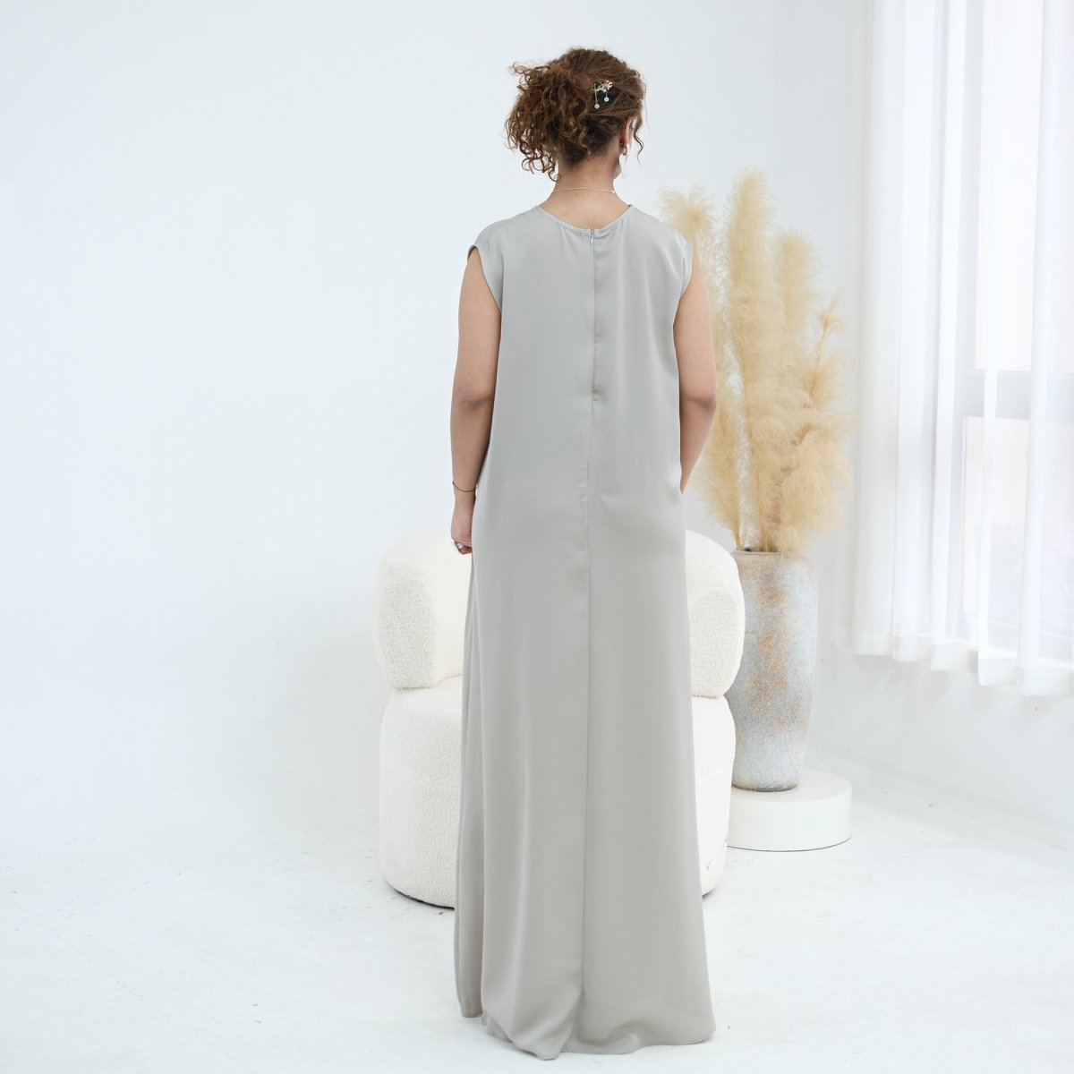Floor-length hem of open abaya draped on model