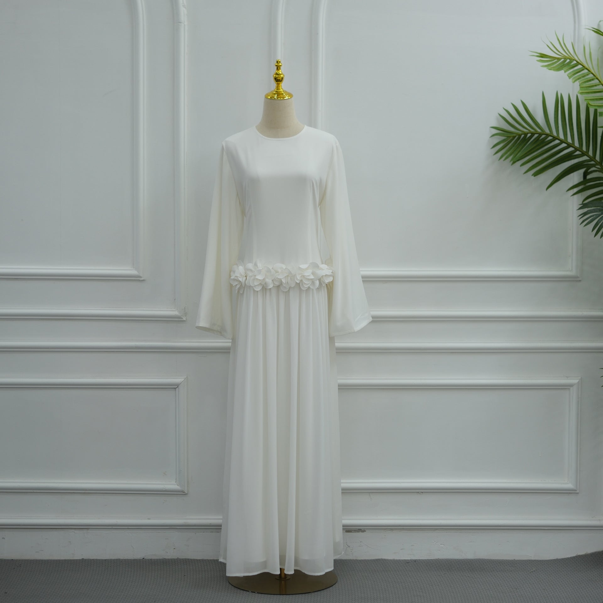 Sculptural rose waist band catching light on fitted maxi dress