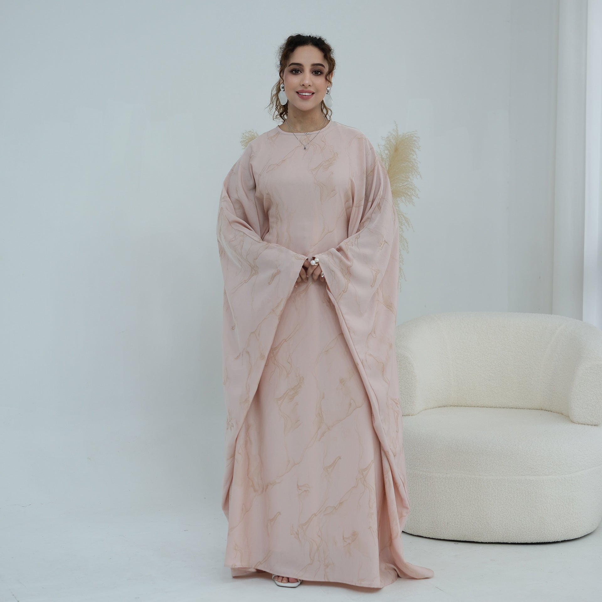 Model in motion wearing gold print modest maxi dress