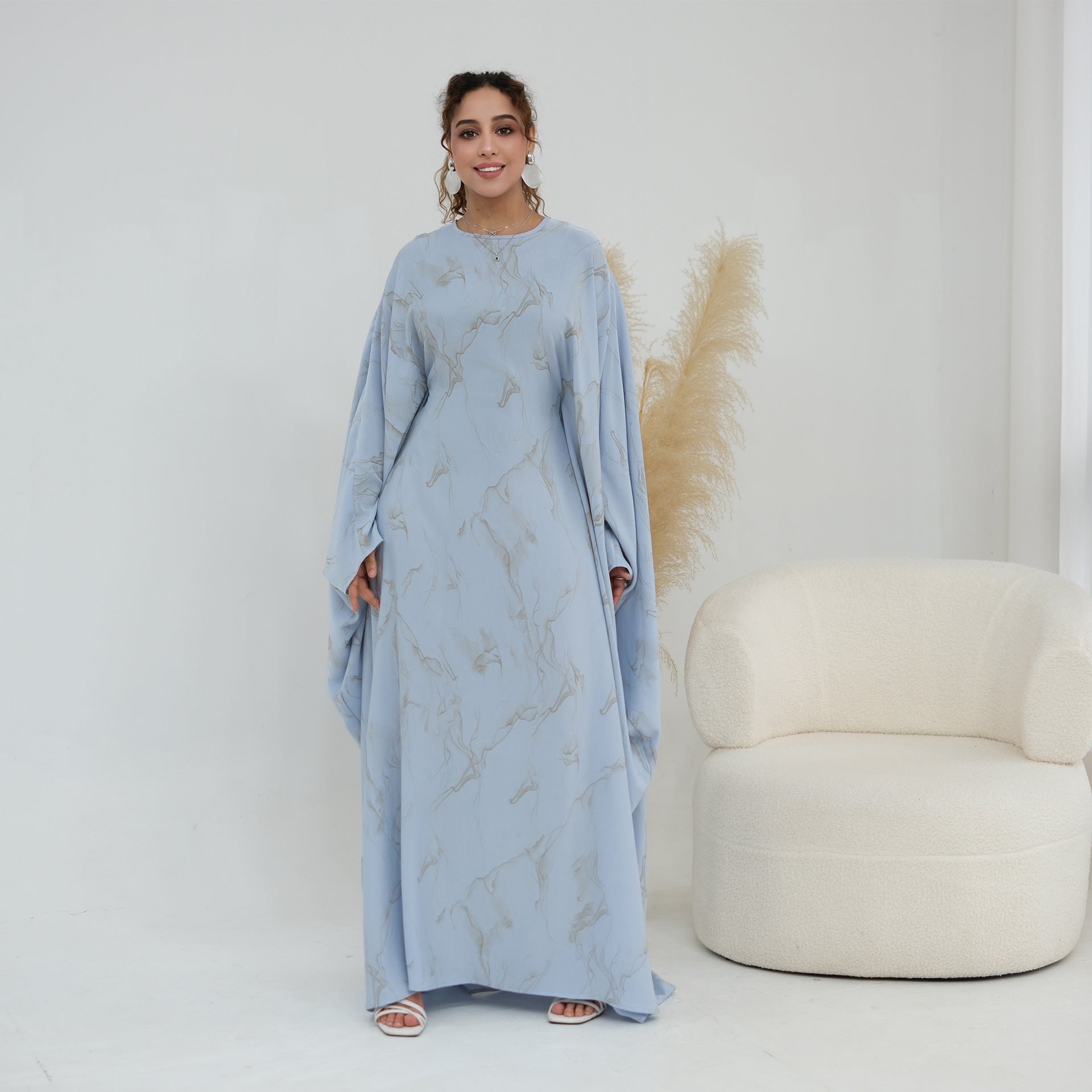 Draped batwing sleeve detail showing feather-print motif