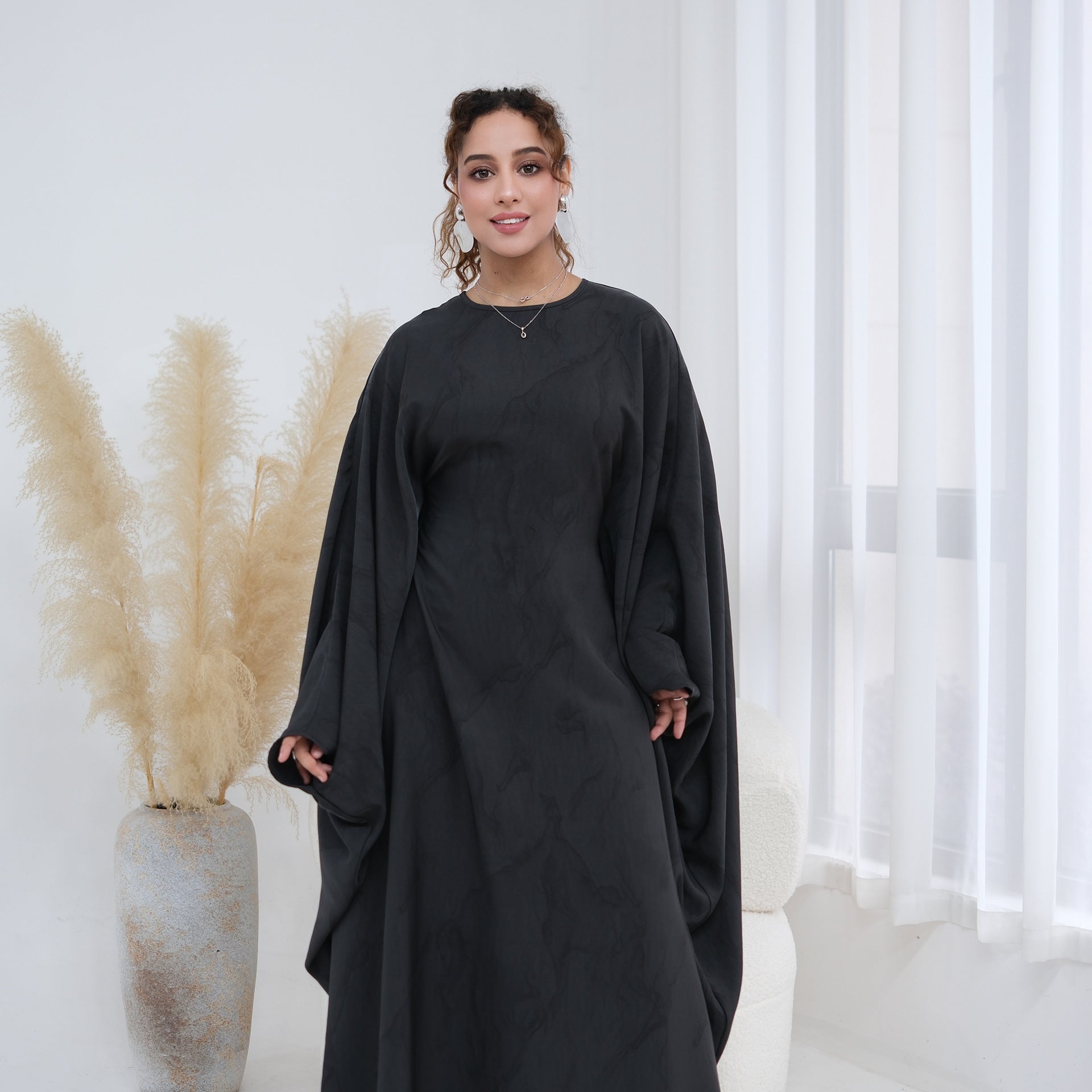 Side profile of gold print batwing sleeve maxi dress belted at waist