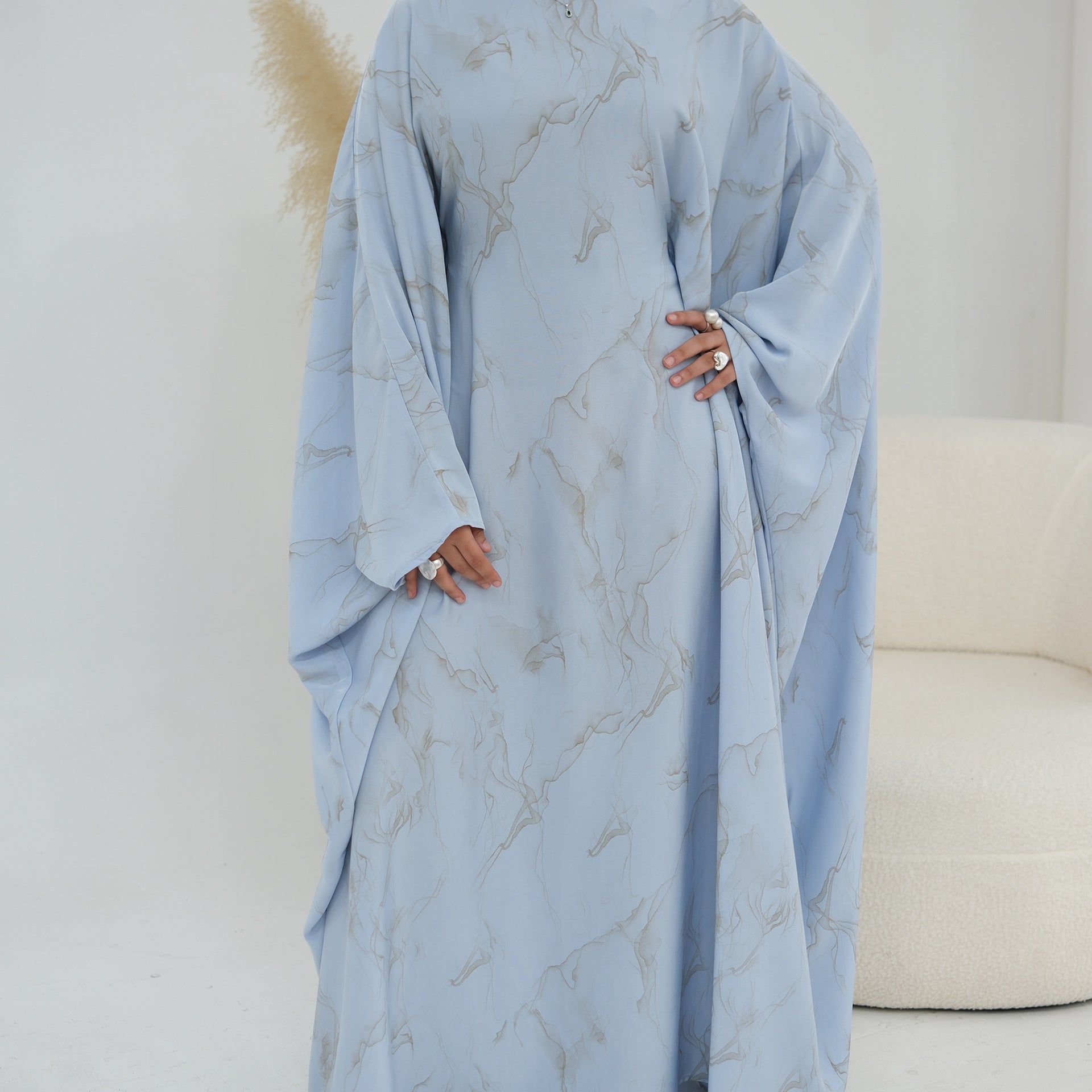 Hem detail of full-length gold marble print modest maxi dress