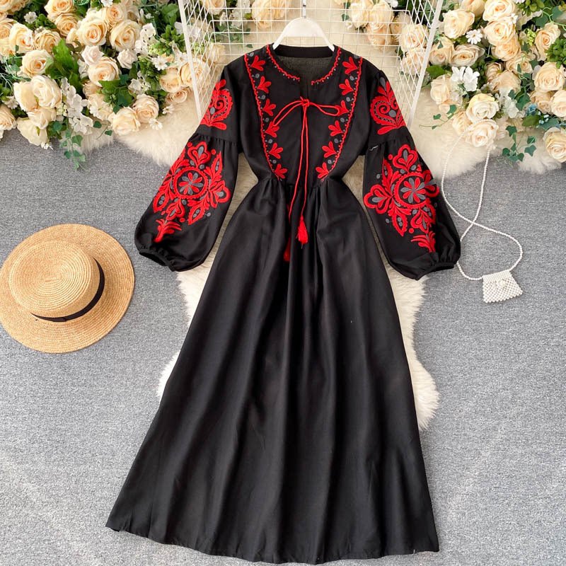 Front view showing red and navy folk embroidery on chest panel of linen maxi dress