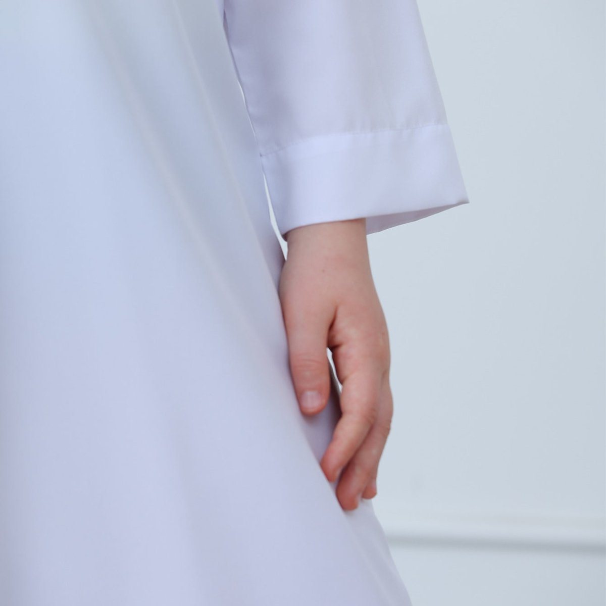 Chest pocket detail with gold button on boys poly-cotton thobe