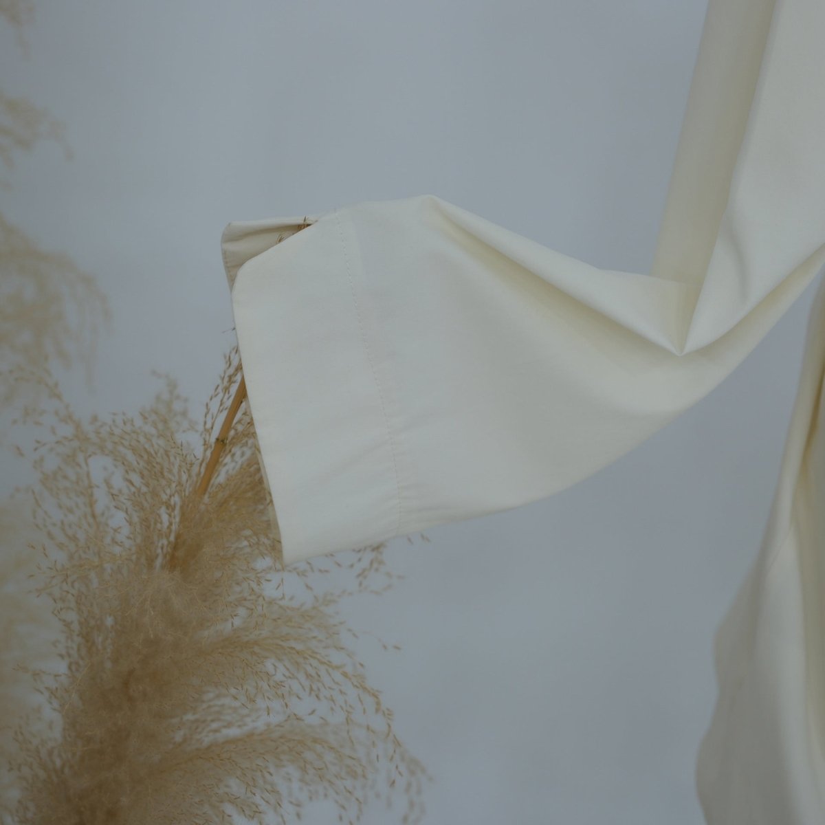 Layered styling of longline top over wide-leg trousers
