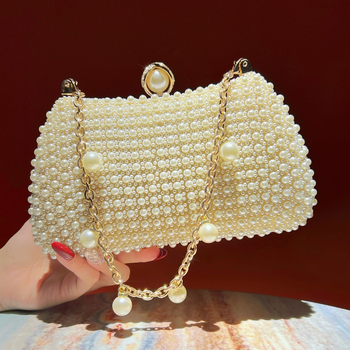 Pearl chain strap bag worn as a shoulder crossbody style