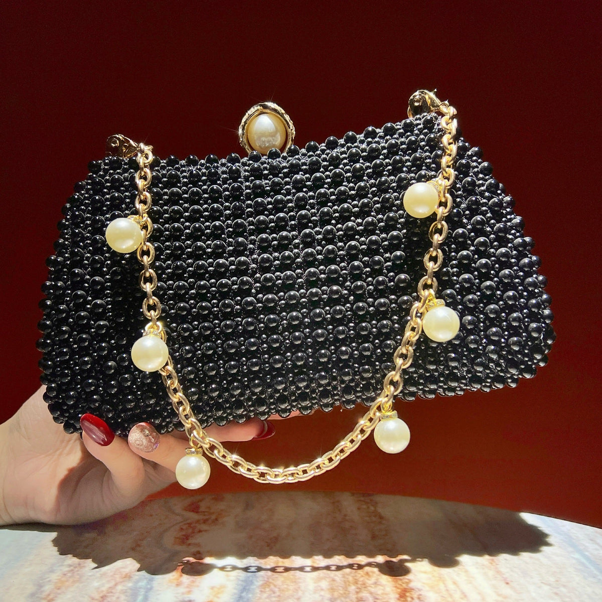 Front view of faux pearl clutch bag with pearl clasp lock closure
