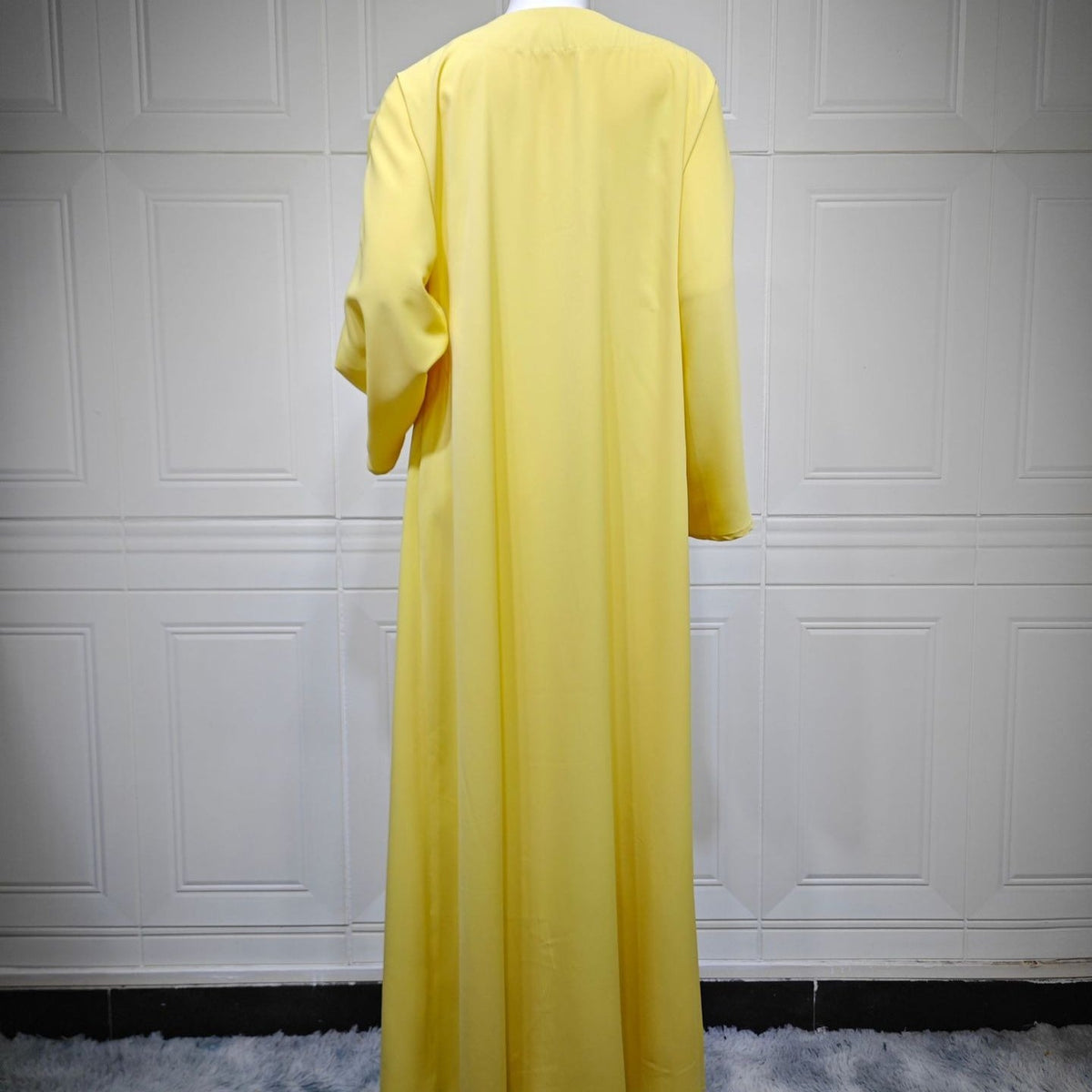 Side profile showing fluid drape and sweeping hem of collarless summer abaya
