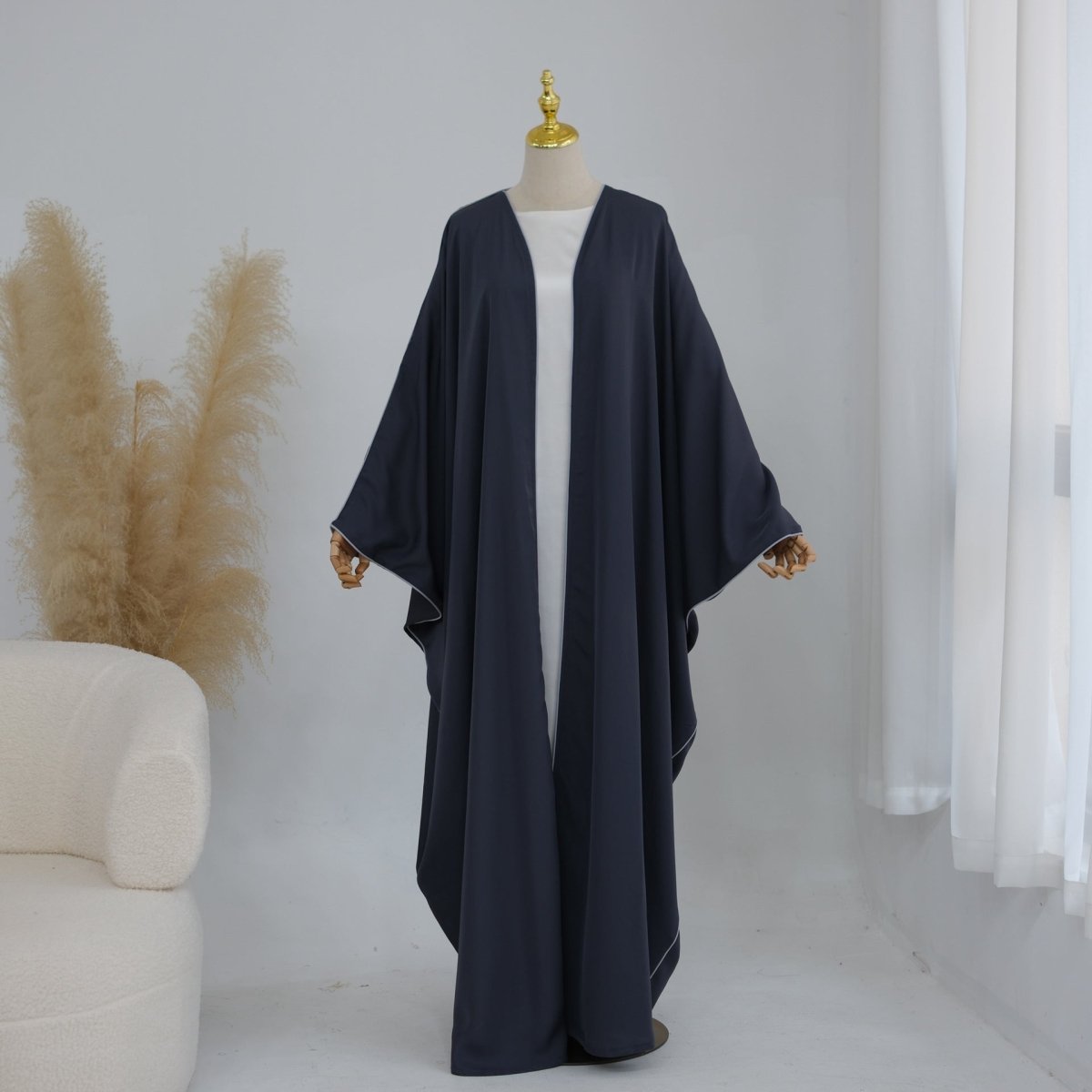 Wide batwing sleeves of open abaya showing layering room underneath