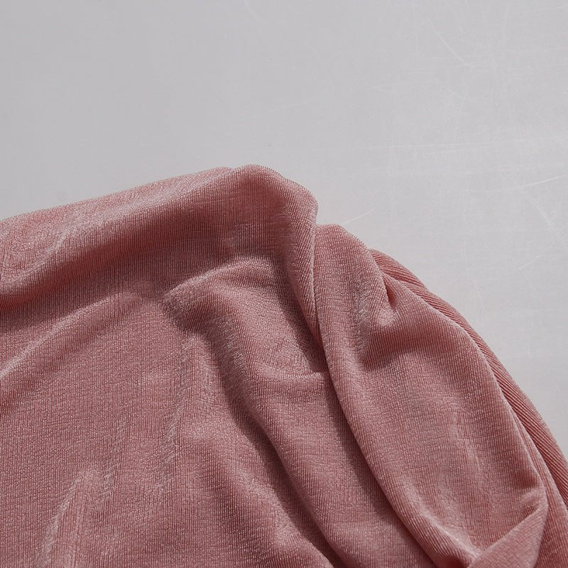 Side profile of fitted ribbed knit maxi dress showing asymmetric gathered hem