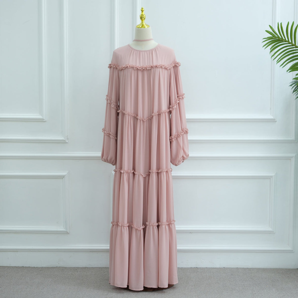 Three-quarter view of tiered maxi dress with waist tie styled loosely