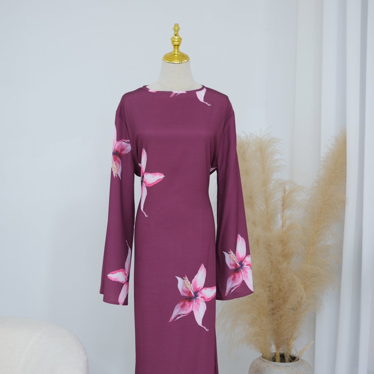 Movement shot showing flowing A-line drape of botanical cape sleeve maxi
