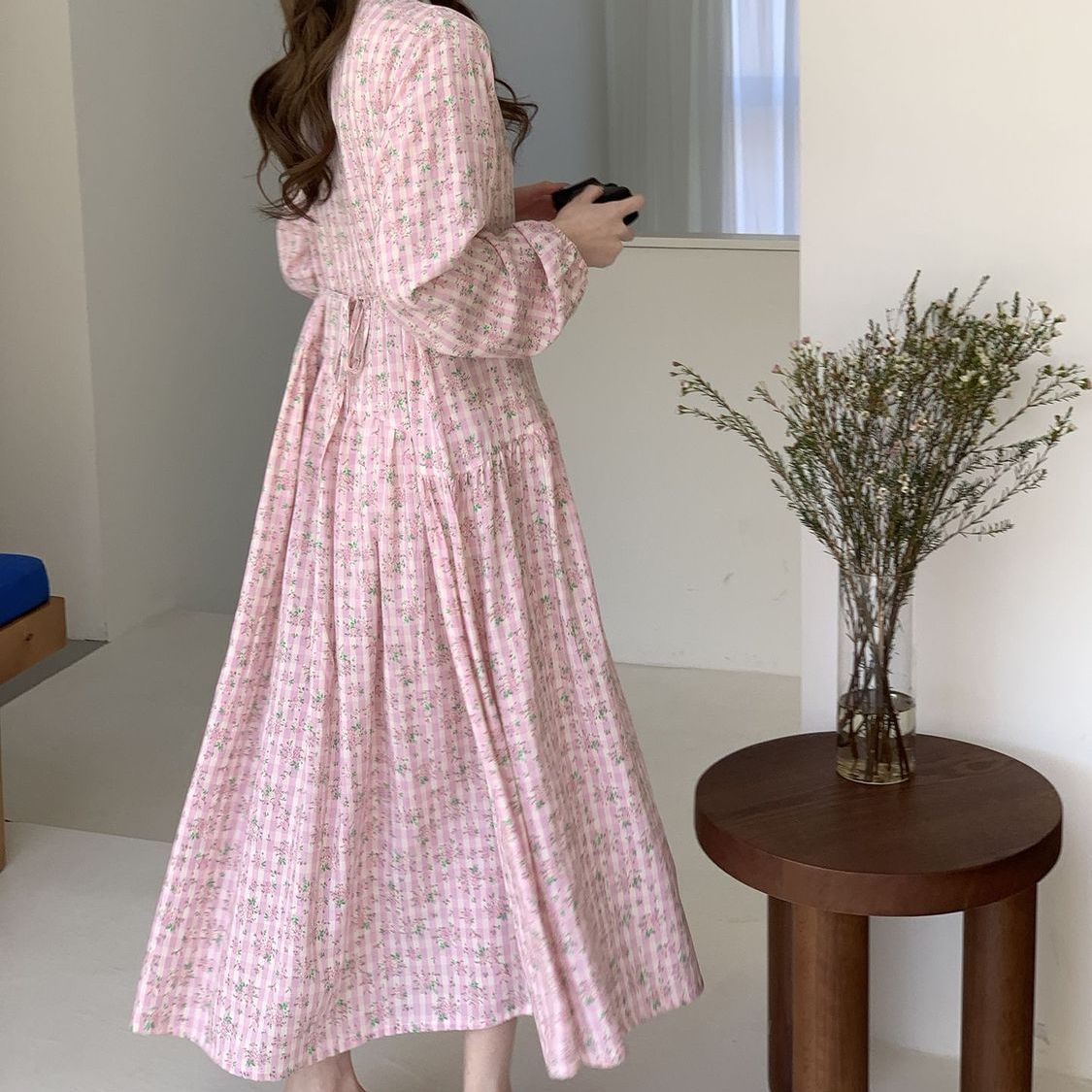 Full-length side view showing sweeping A-line gathered skirt of floral maxi dress