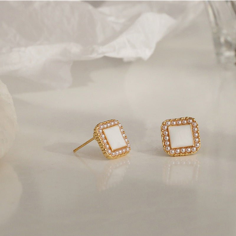 Side view of geometric pearl stud earrings showing post and butterfly backing