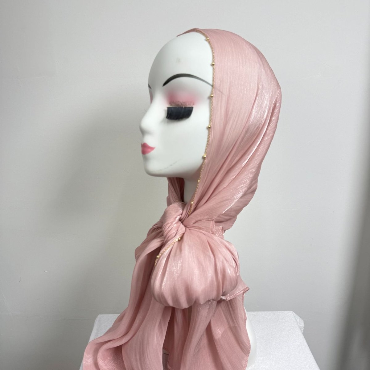 Gold beaded edge hijab in soft blush tone showing lustrous sheen