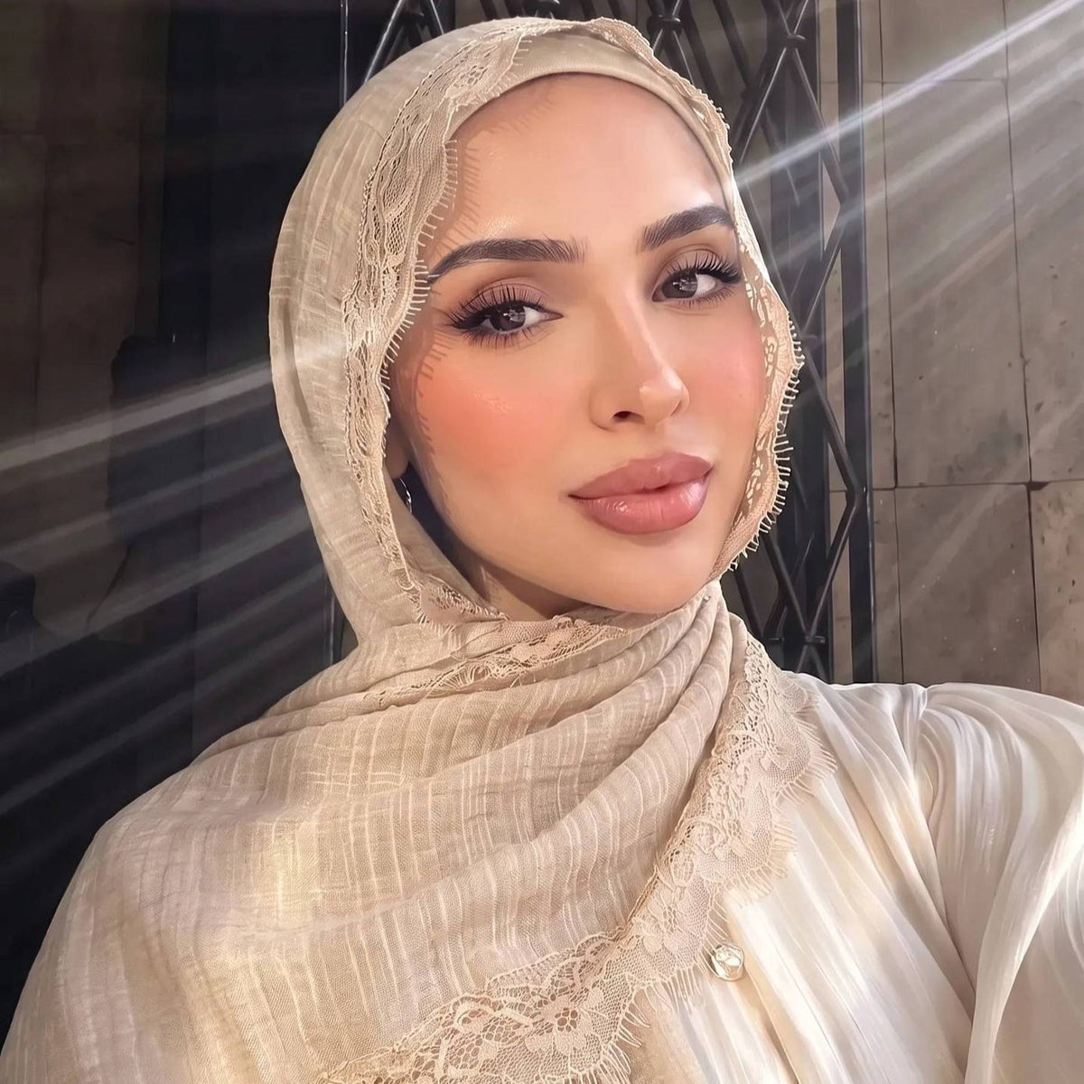 Lace trim hijab styled as a shoulder shawl over modest wear
