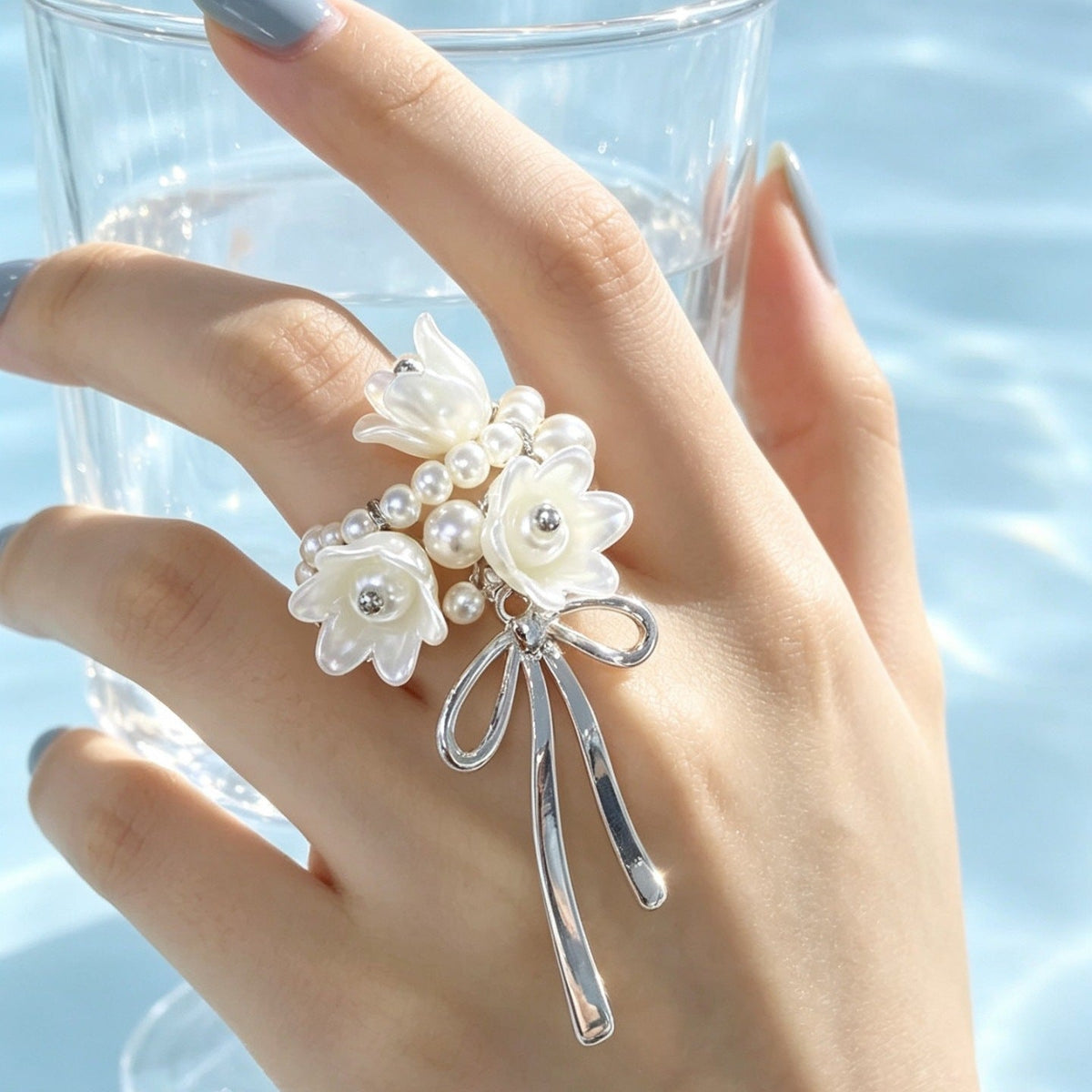 Lily of the valley floral ring worn on index finger showing full bow silhouette