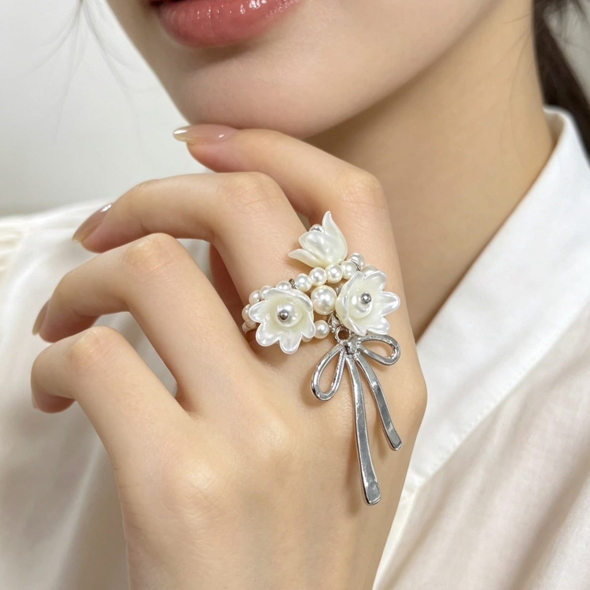Top-down view of pearl bow statement ring highlighting lustrous cluster pearls