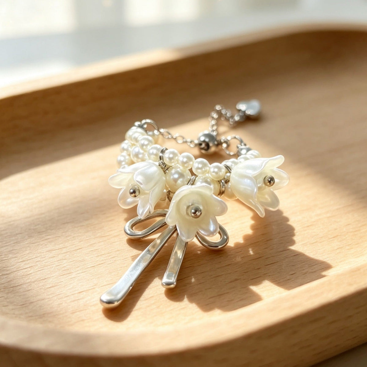 Side profile of open-band adjustable ring with delicate bell-blossom charms