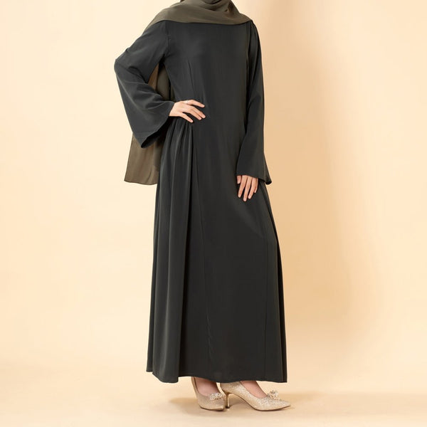 Side view of pleated A-line nida dress showing flowing skirt volume