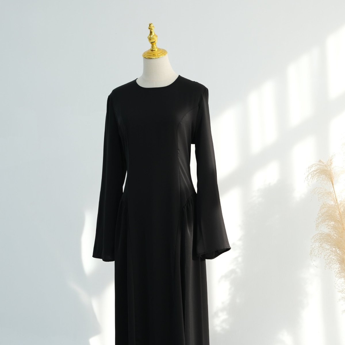 Close-up of pleated skirt volume on floor-length nida maxi dress